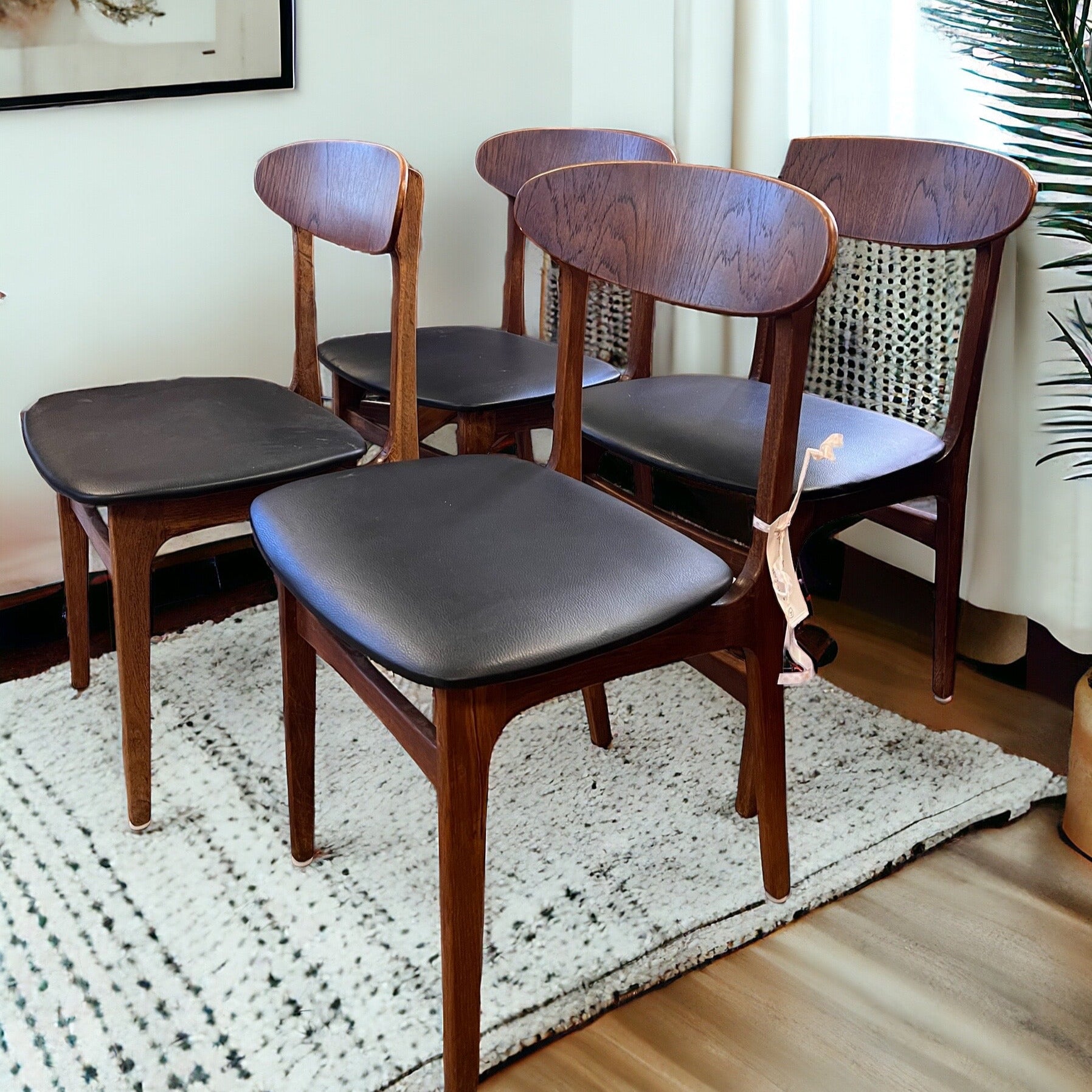 De fyra stolarna har en vackert svängd rygg och bred sits vilket gör dem bekväma att sitta i. Stolarna är i teak med svart konstläder eller skai som det också kallas för. 