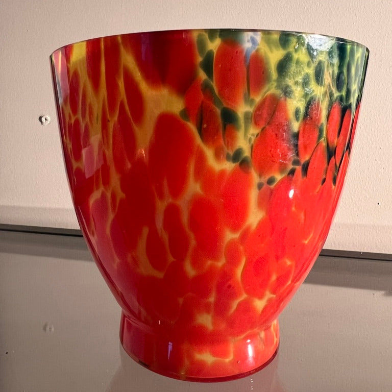 Mångfärgad glasmassa i form av konstglas som en kruka eller skål.