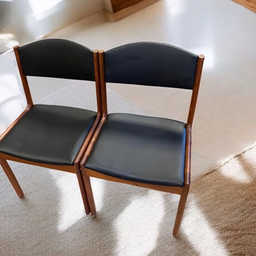 Två teakstolar omklädda med fustskinn.