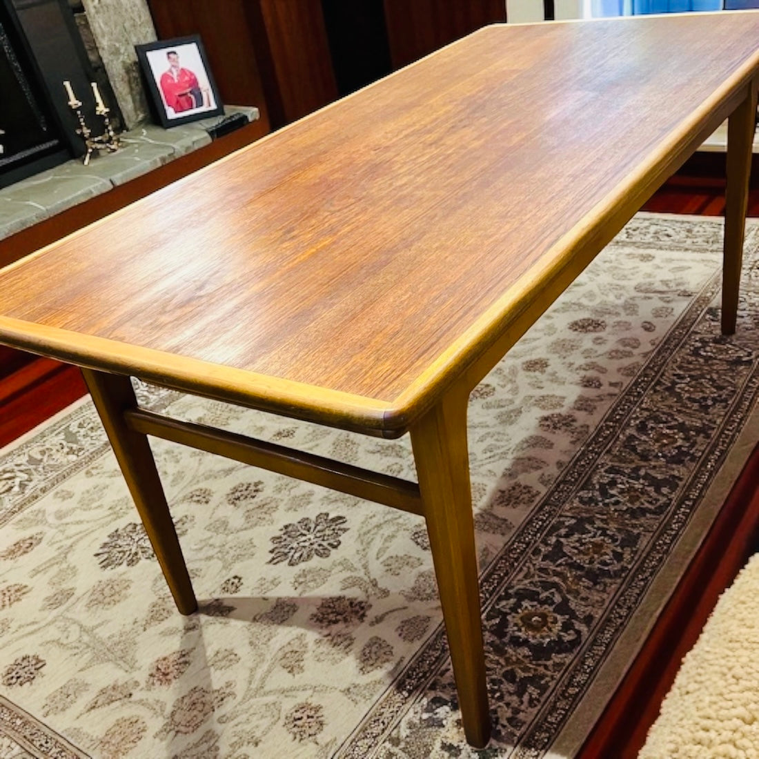 Det här eleganta soffbordet i varm teakton är både stilrent och praktiskt – med en enkel rörelse höjs och fälls det ut till ett matbord. 