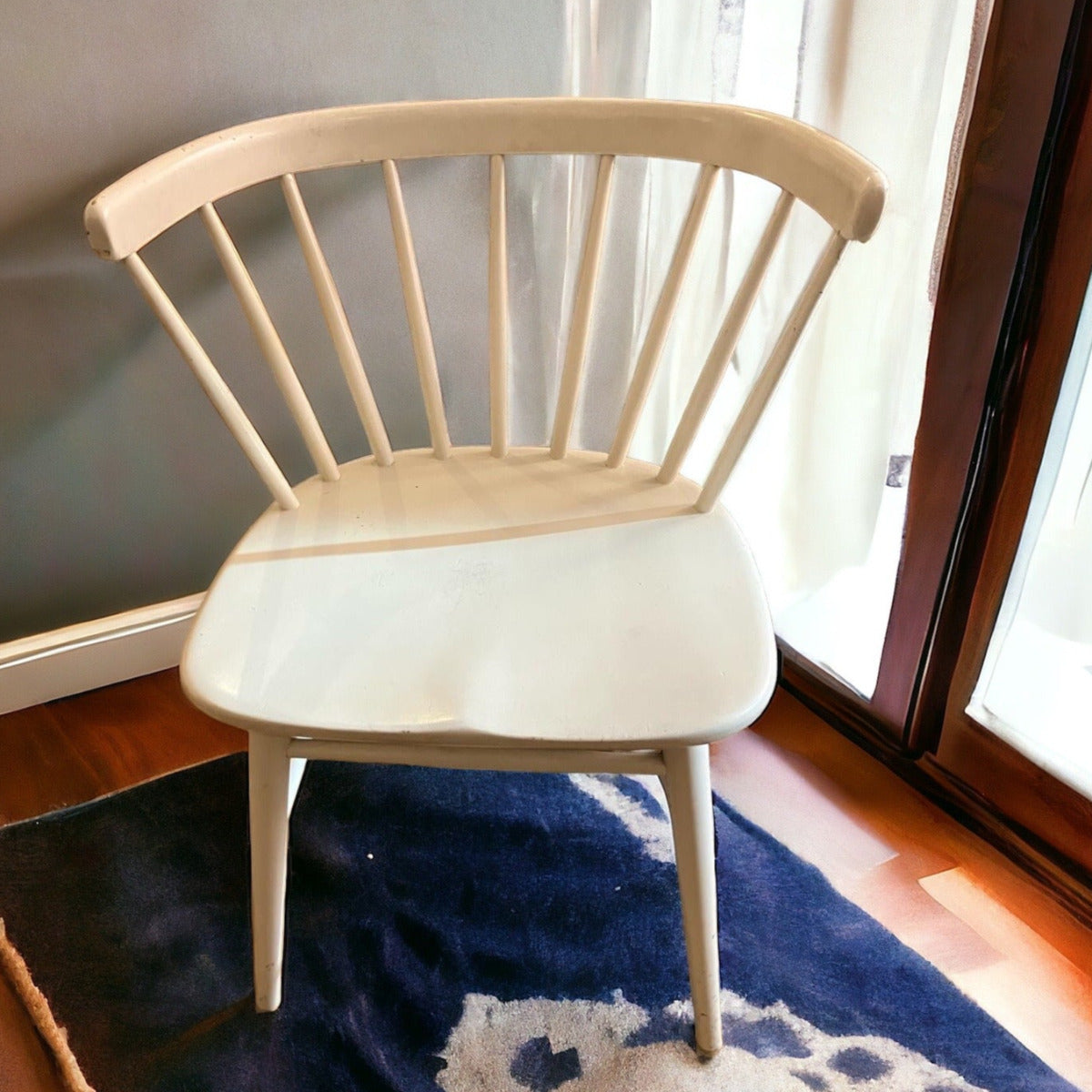 Karmstolen "Florida" från Bröderna Wigells Stolfabrik är en vitmålad stol med karakteristiska spjälor i ryggen. 