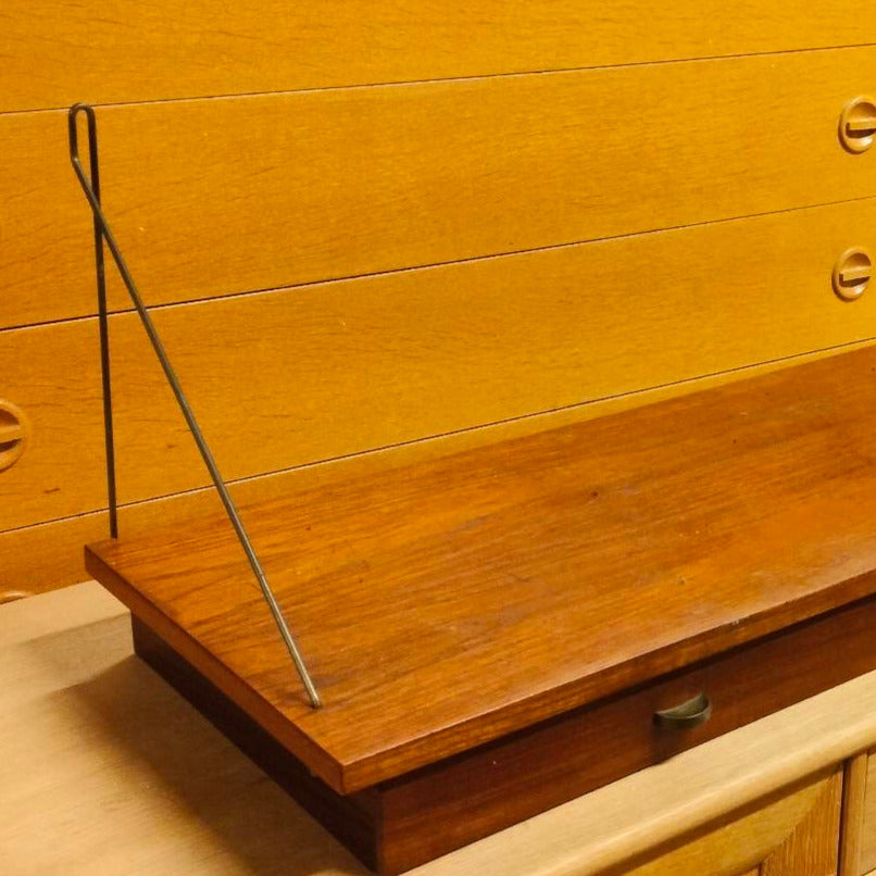 Vägghängdhylla i teak med två lådor med träknopp. Hyllan har fina originalkonsol.