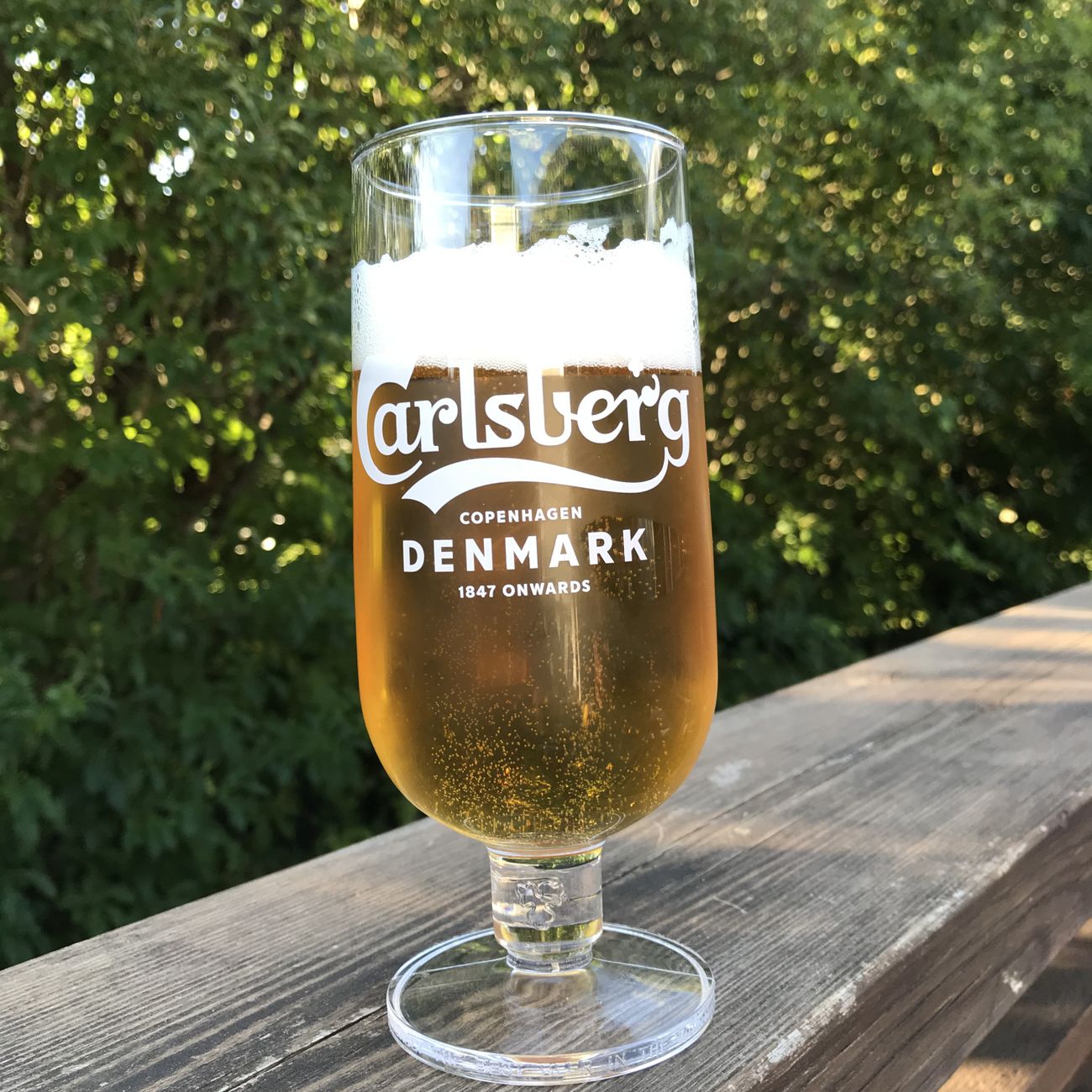Ölglaset Carlsberg med fot finns i ett set om sex glas, samtliga prydda med den ikoniska Carlsberg-loggan och stående på en liten fot som ger extra stabilitet och elegans. 